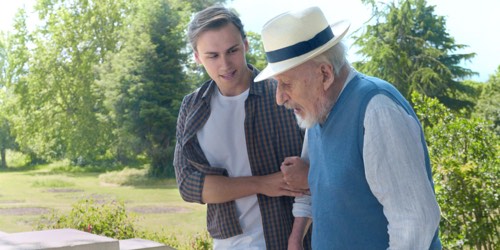 Younger man helping an older man to walk outside Younger man helping an older man to walk outside